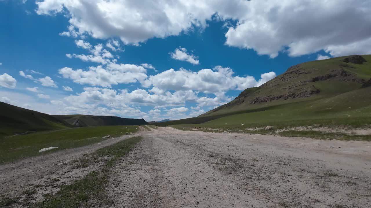 沿着山河行驶在土石路上。汽车的观点视频下载