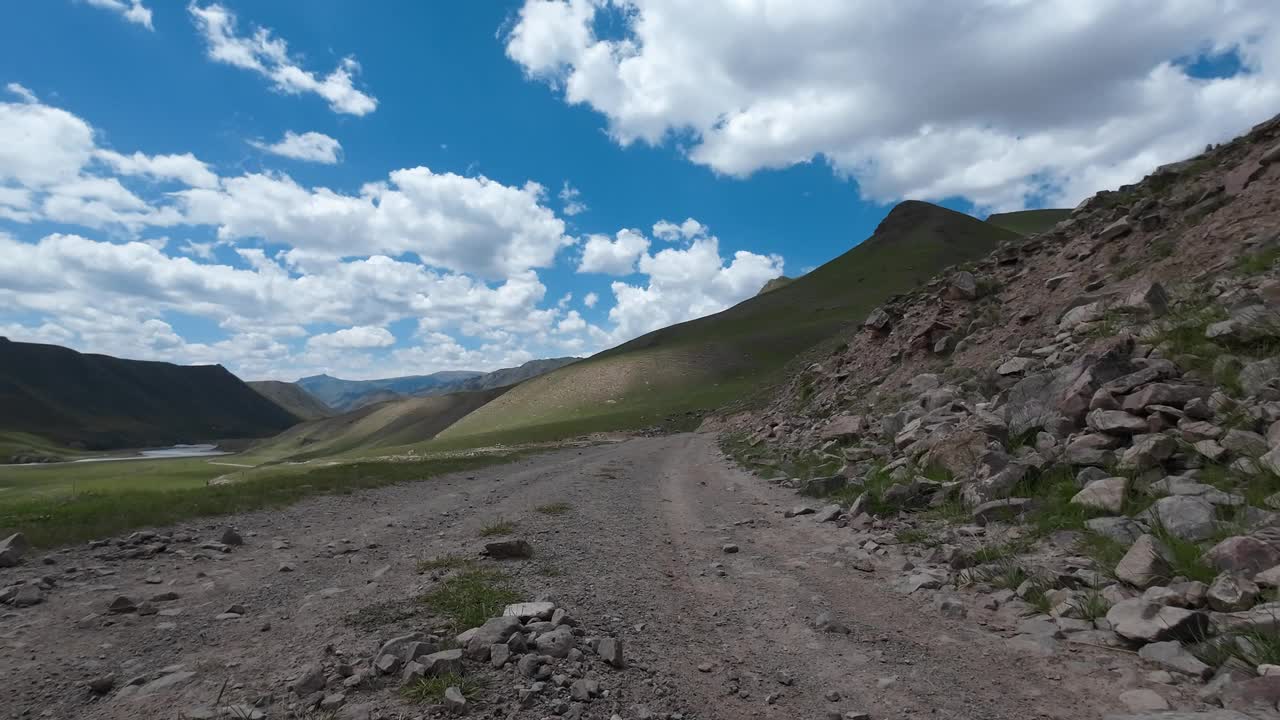 沿着山河行驶在土石路上。汽车的观点视频下载