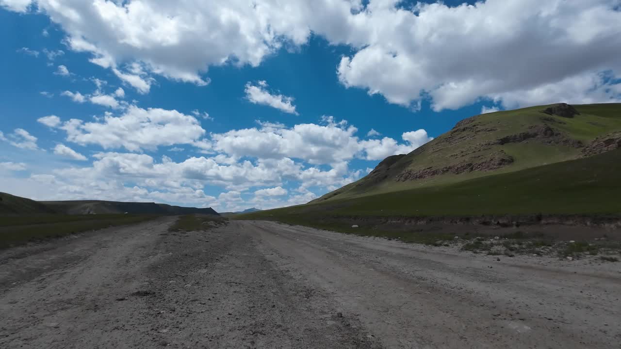 沿着山河行驶在土石路上。汽车的观点视频素材