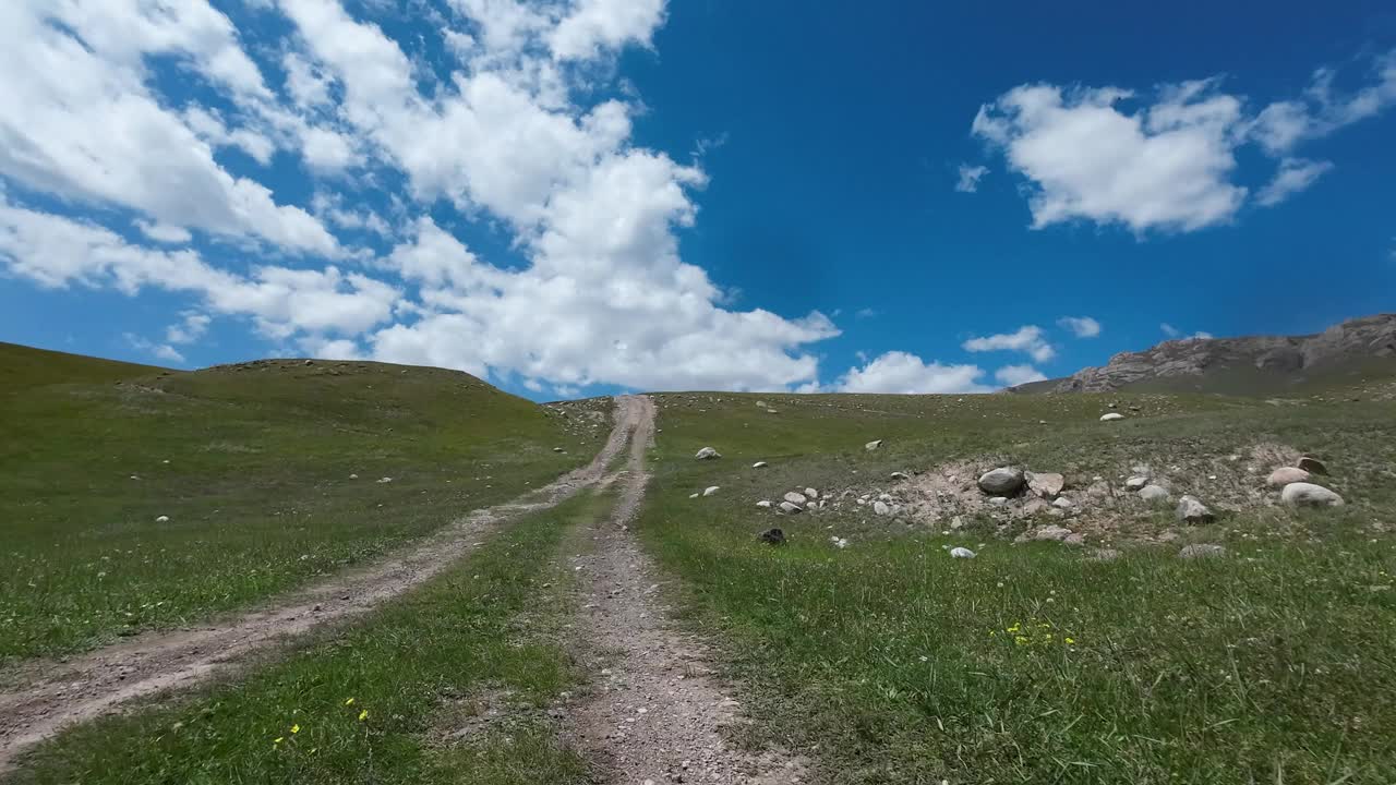 沿着山河行驶在土石路上。汽车的观点视频素材