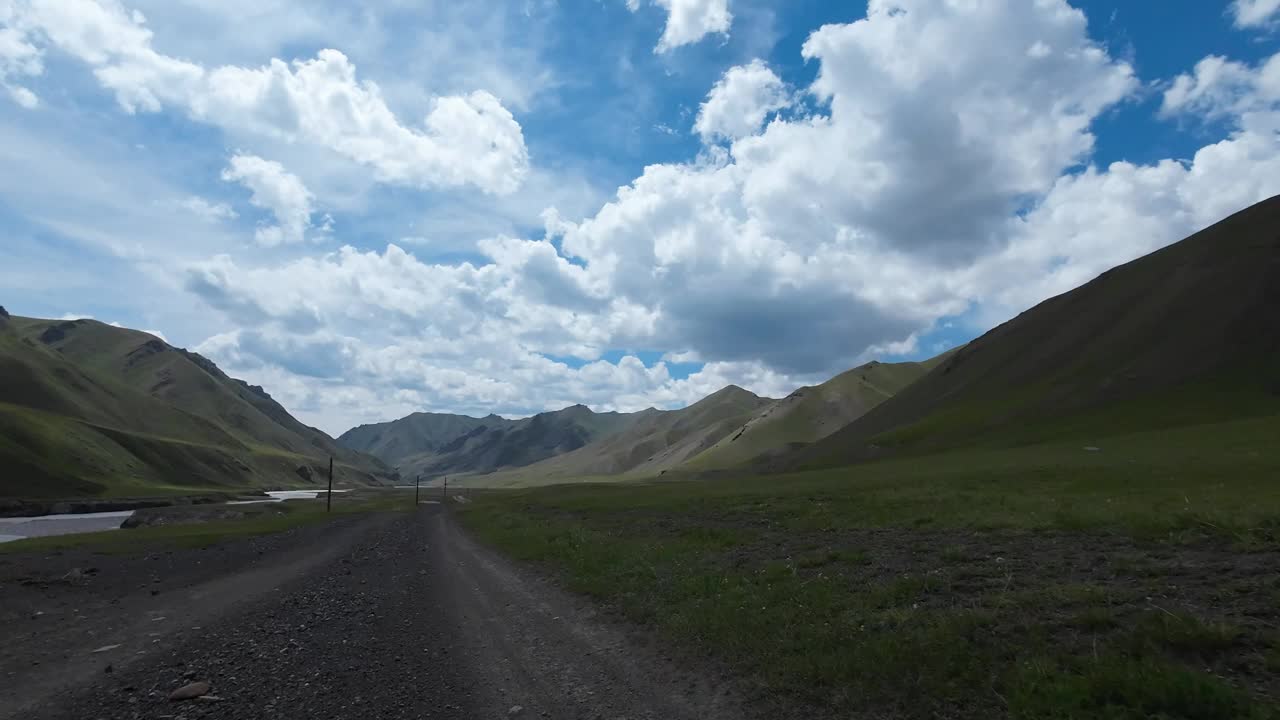 沿着山河行驶在土石路上。汽车的观点视频下载