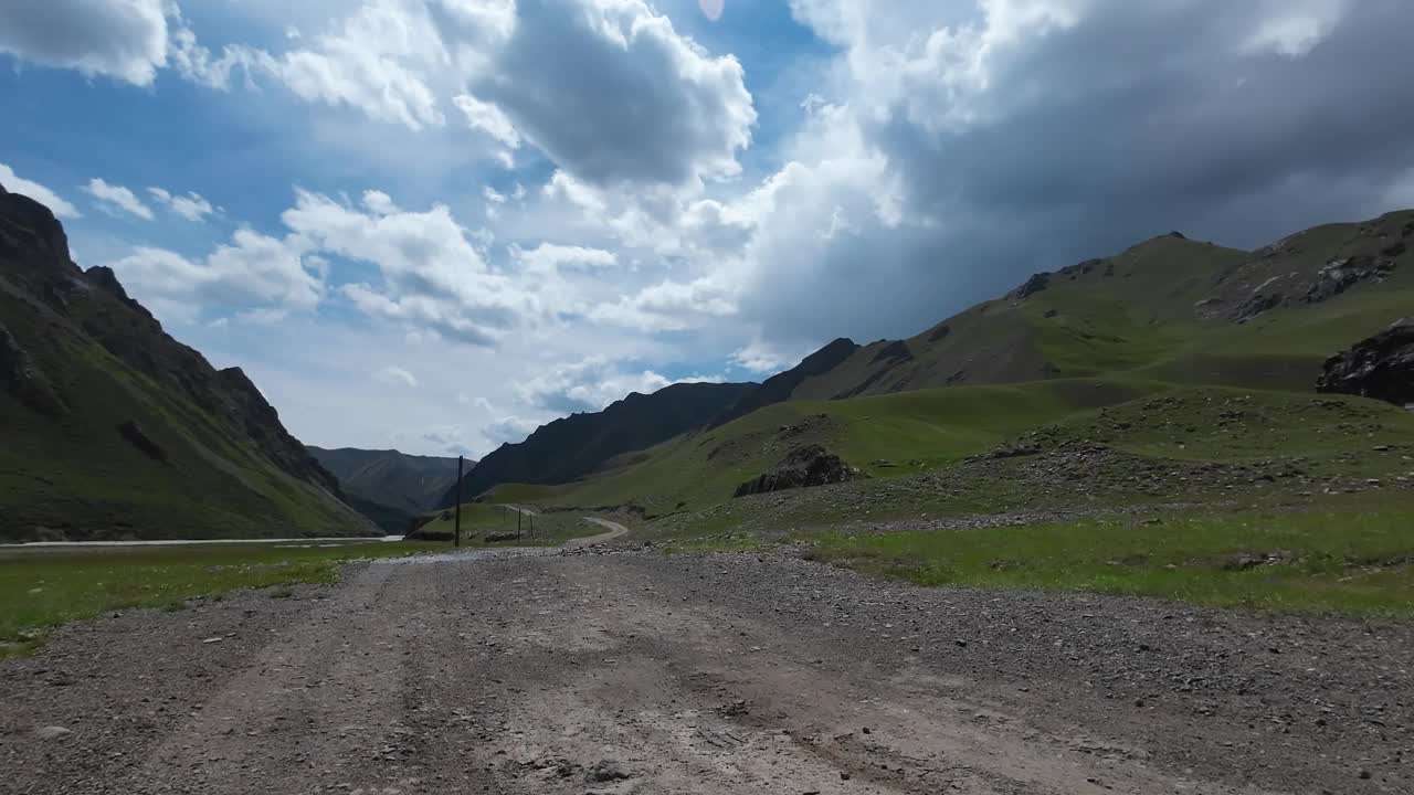 沿着山河行驶在土石路上。汽车的观点视频素材