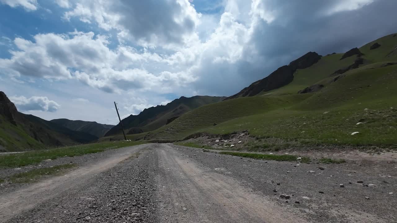 沿着山河行驶在土石路上。汽车的观点视频素材