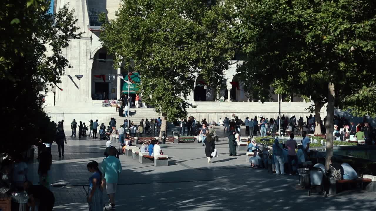 倾斜。人们在Yeni Cami清真寺前的街景。伊斯坦布尔的米诺努广场视频素材