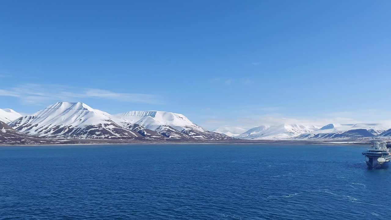 宁静的冬季景观:雄伟的山脉，原始的雪，和宁静的大海从斯瓦尔巴群岛和扬马延挪威的观点视频下载