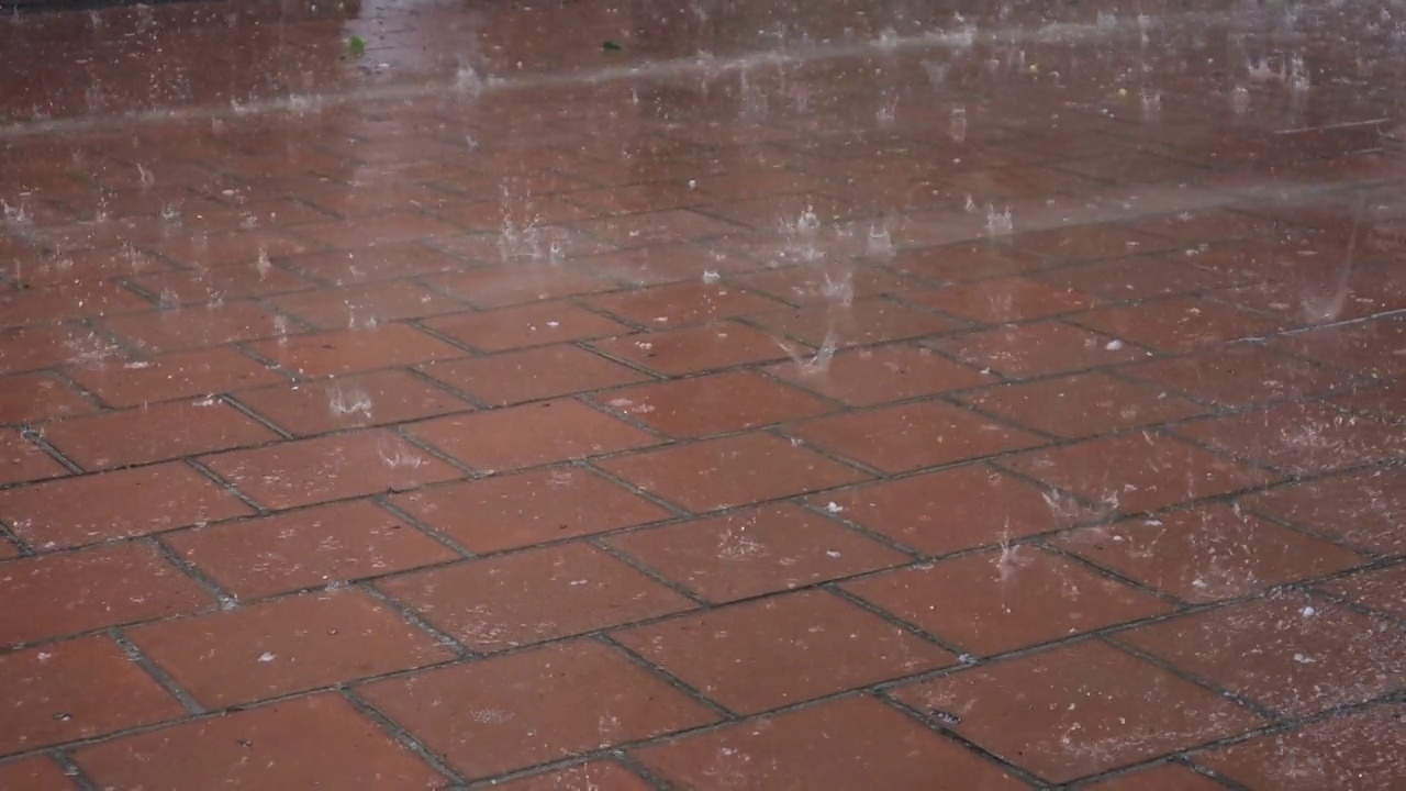 夹杂着冰雹的大雨点落在石板上。视频素材