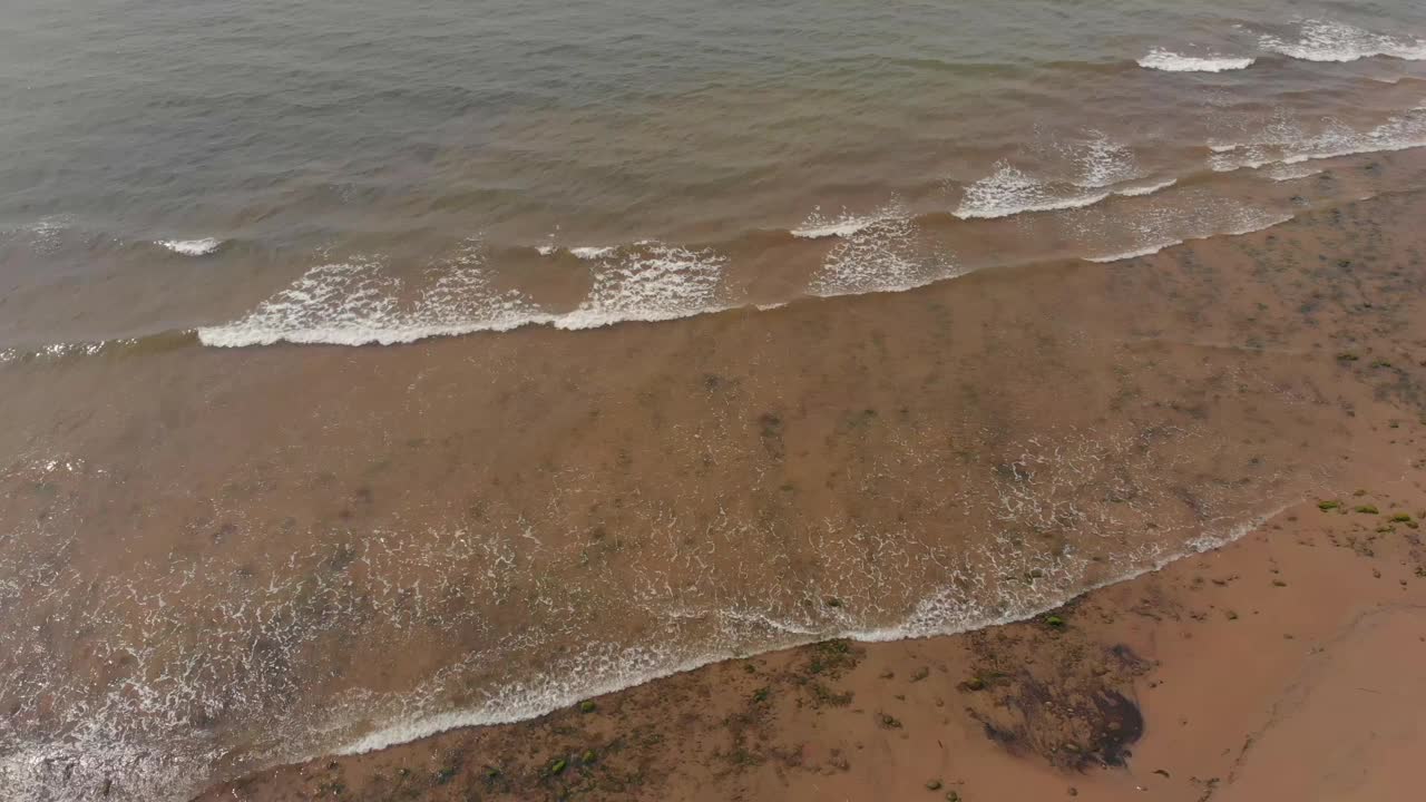 无人机拍摄的海景，平静的海浪和棕色的沙滩视频素材