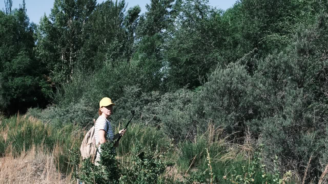 一位成熟的女游客正在小山城的河边拍视频视频素材