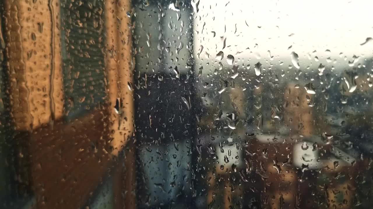 雨点顺着窗户流下来的慢镜头。概念视频素材