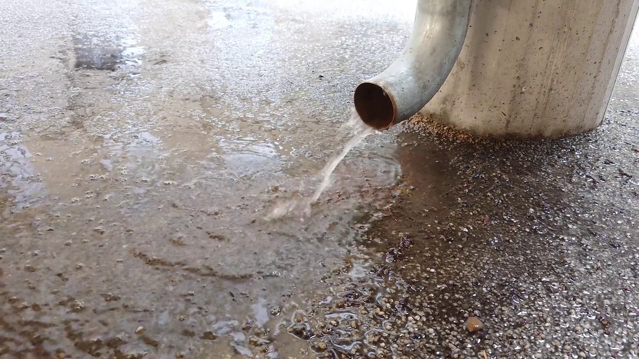 雨水:从雨沟或排水管流出的雨水低角度，近距离拍摄，实时，没有人视频素材