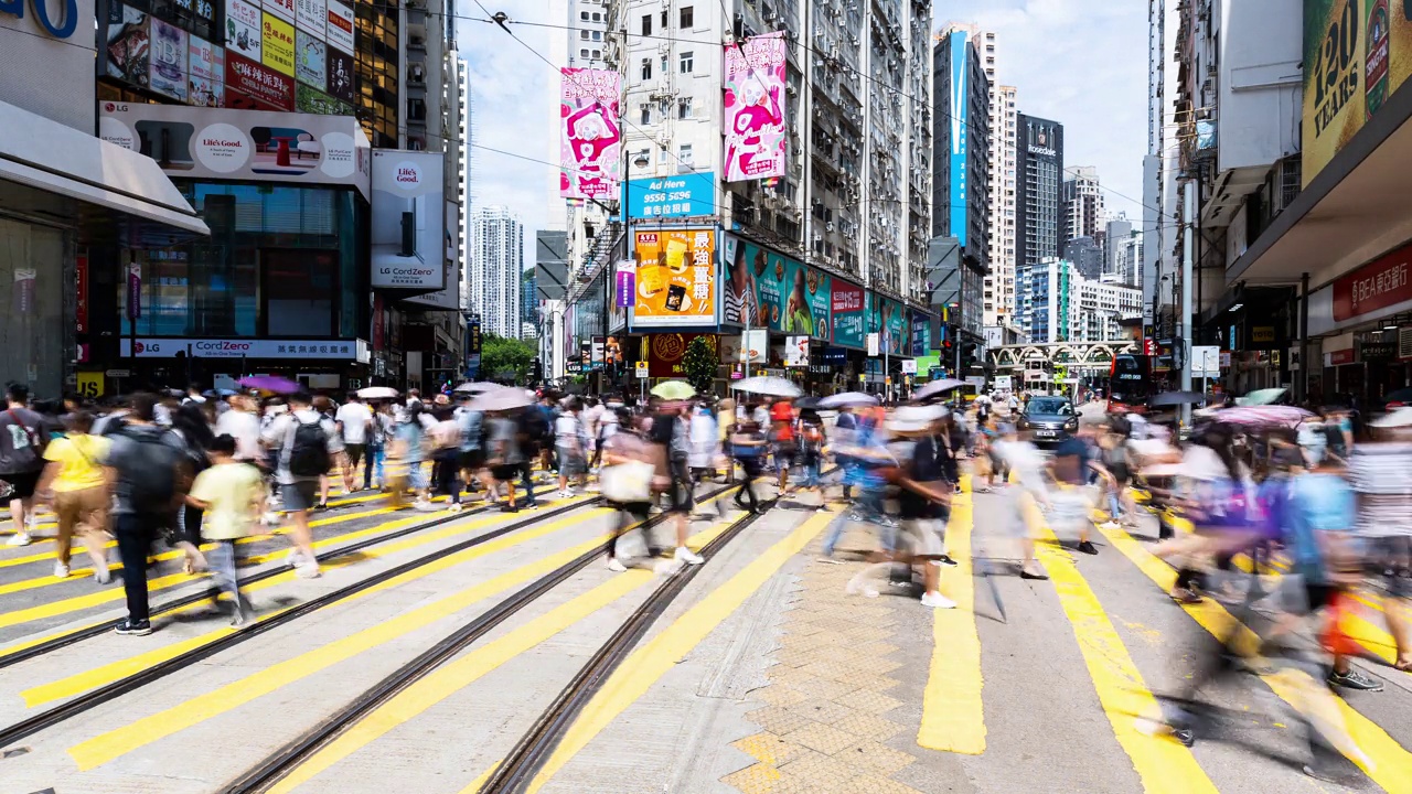 香港铜锣湾购物区的中国人走过斑马线。有轨电车、公共汽车、汽车和出租车交通运输。亚洲交通城市生活，亚洲旅游理念视频素材