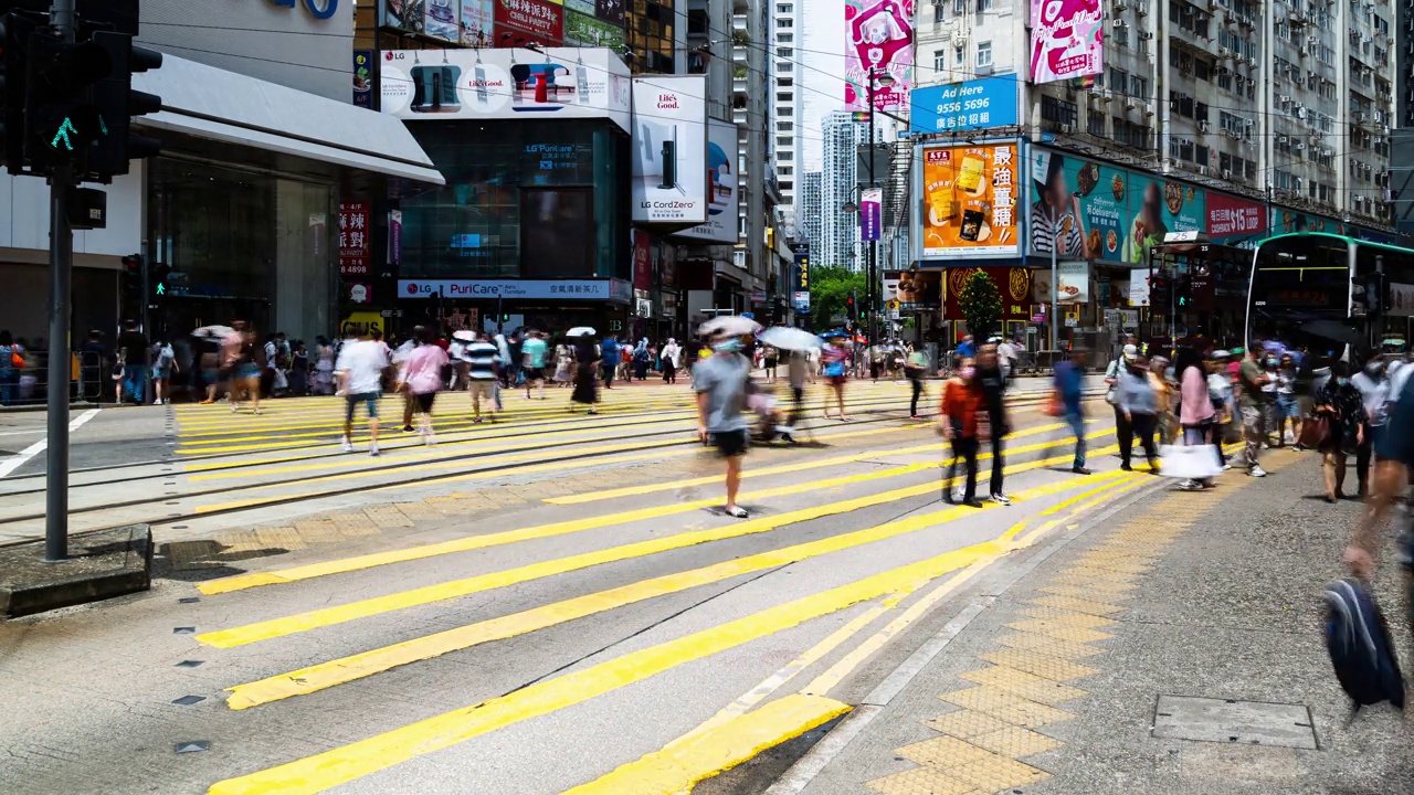 香港铜锣湾购物区的中国人走过斑马线。有轨电车、公共汽车、汽车和出租车交通运输。亚洲交通城市生活，亚洲旅游理念视频素材