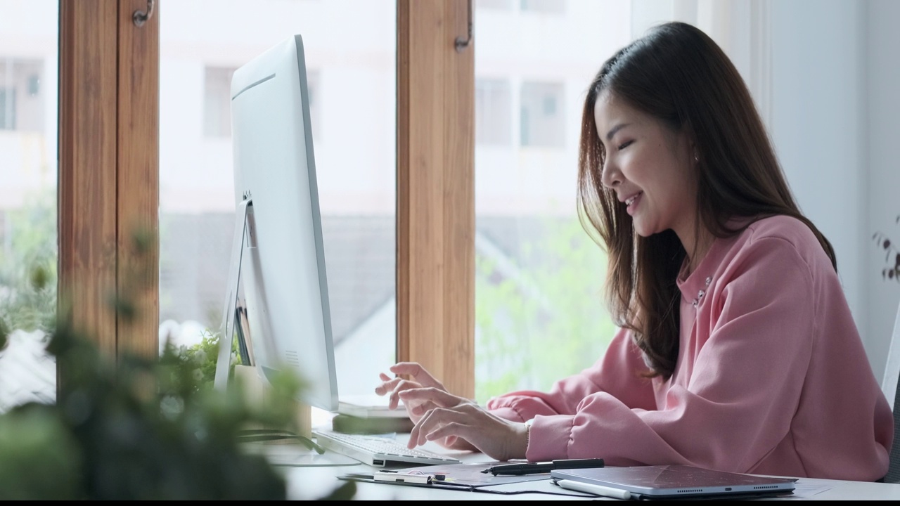 有魅力的亚洲女性市场业务经理，在办公桌旁准备报告和打字商务邮件。视频素材