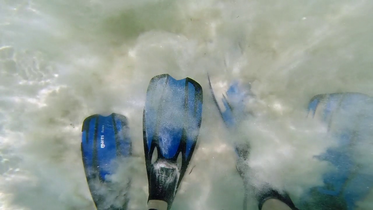 潜水员鳍的特写，一个浮潜者入水，鳍在沙子里，进入海洋。视频素材