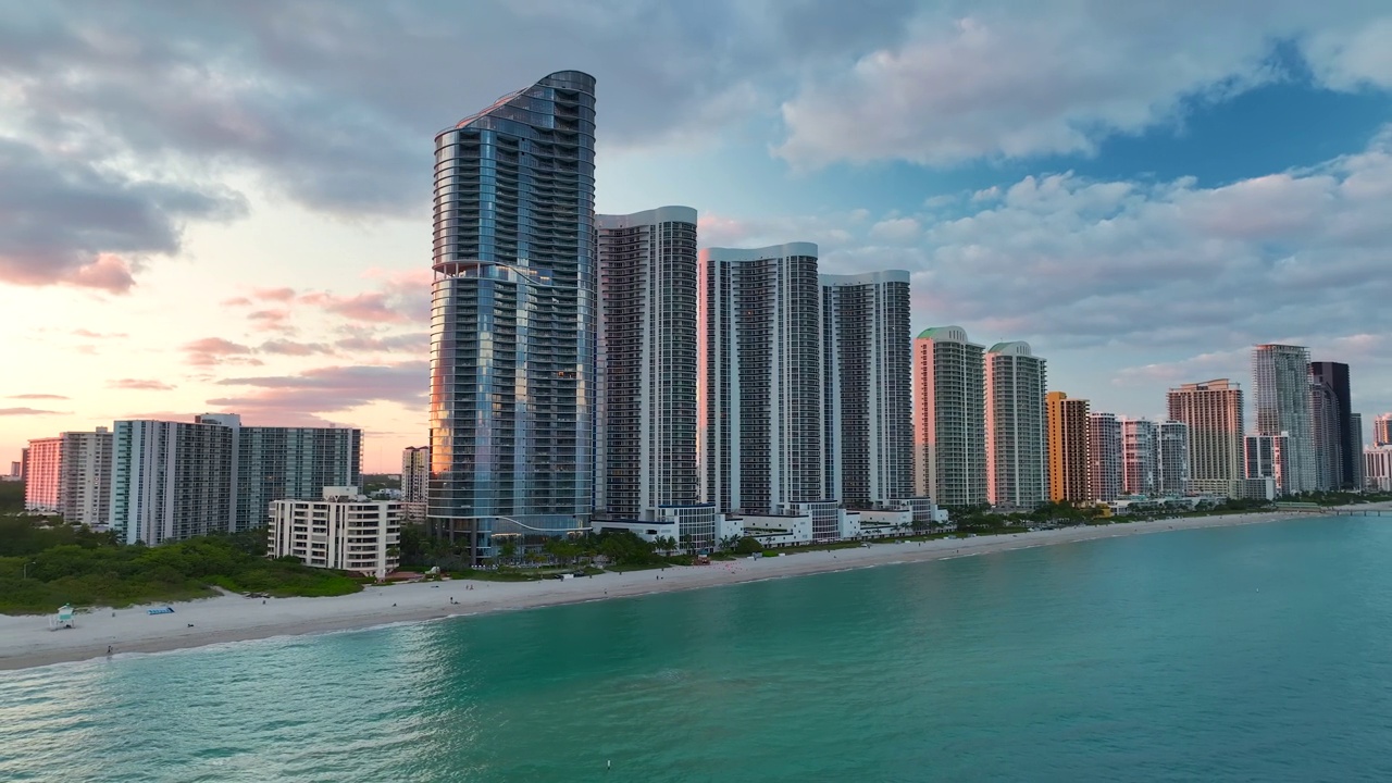 阳光岛海滩城市在日落时的高角度视图，在大西洋海岸的海滨有昂贵的高层酒店和公寓建筑。佛罗里达州南部沿海的美国旅游基础设施视频素材