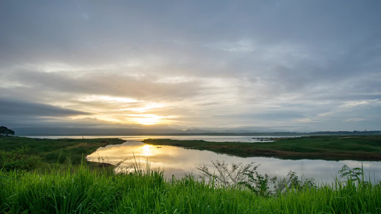 夕阳在水库，橙色的光在一个阴天的晚上。视频下载