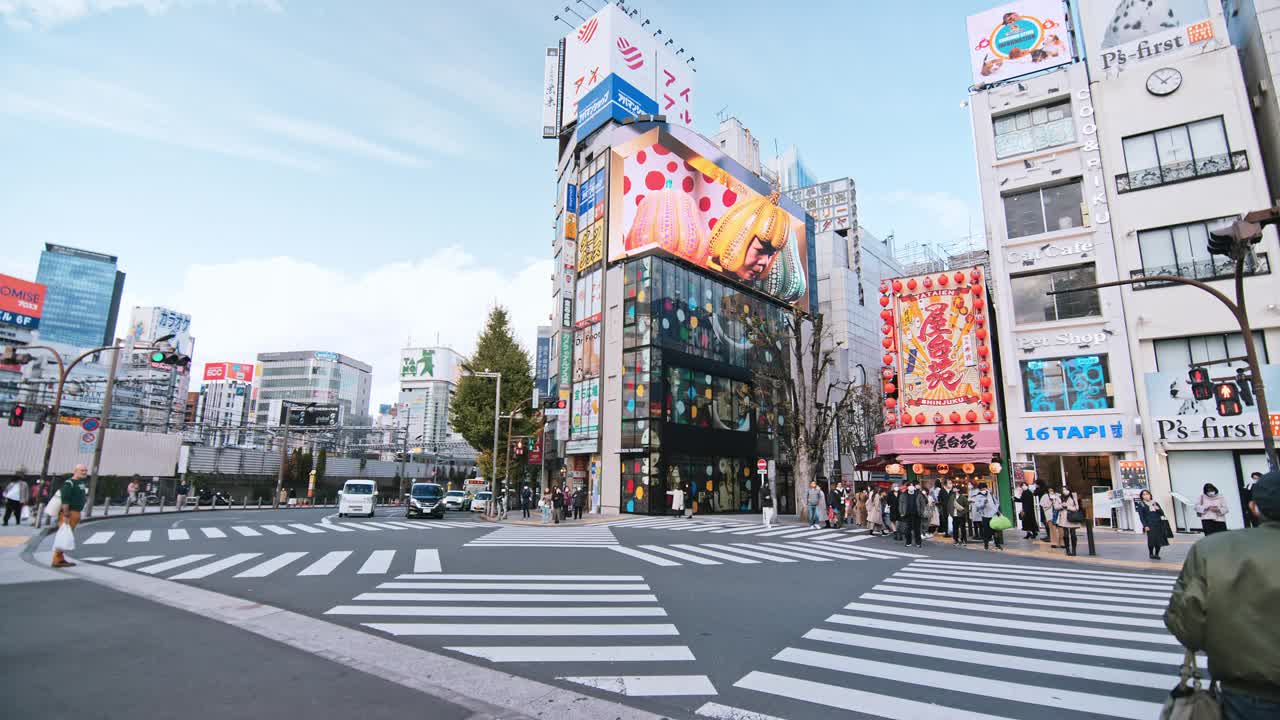 拥挤的人们步行过马路，汽车交通运输在新宿购物金融商务区。东京旅游景点地标，日本旅游，亚洲交通或亚洲城市生活概念视频下载