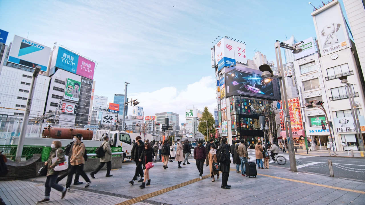 拥挤的人们步行过马路，汽车交通运输在新宿购物金融商务区。东京旅游景点地标，日本旅游，亚洲交通或亚洲城市生活概念视频下载