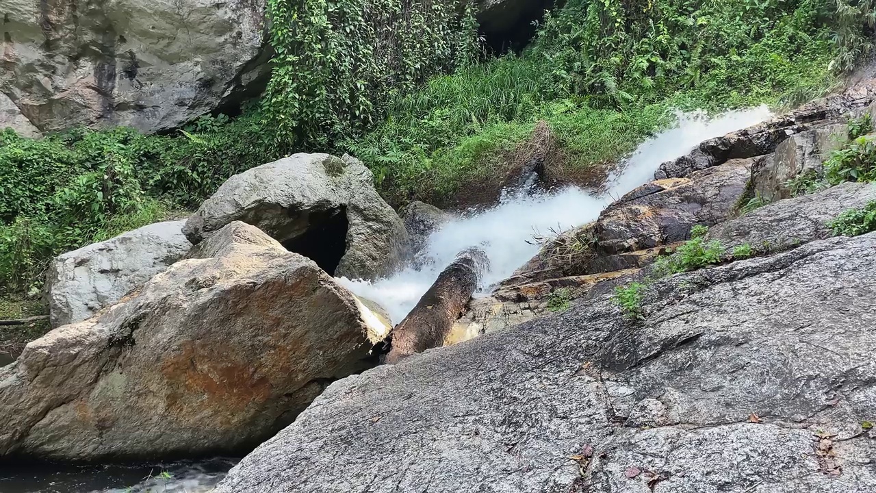 一条河从岩石上流过。丛林流。水流过石头。水流打在岩石上形成泡沫。沿着岩石流下的河流。视频素材