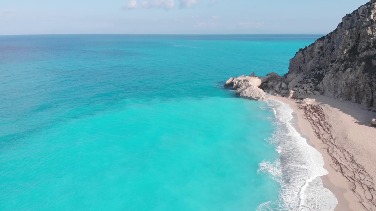 空中美丽的海滩和水湾在希腊壮观的海岸线。碧蓝透明的海水，独特的岩石悬崖，希腊夏季旅游的首选目的地莱夫卡达岛视频下载