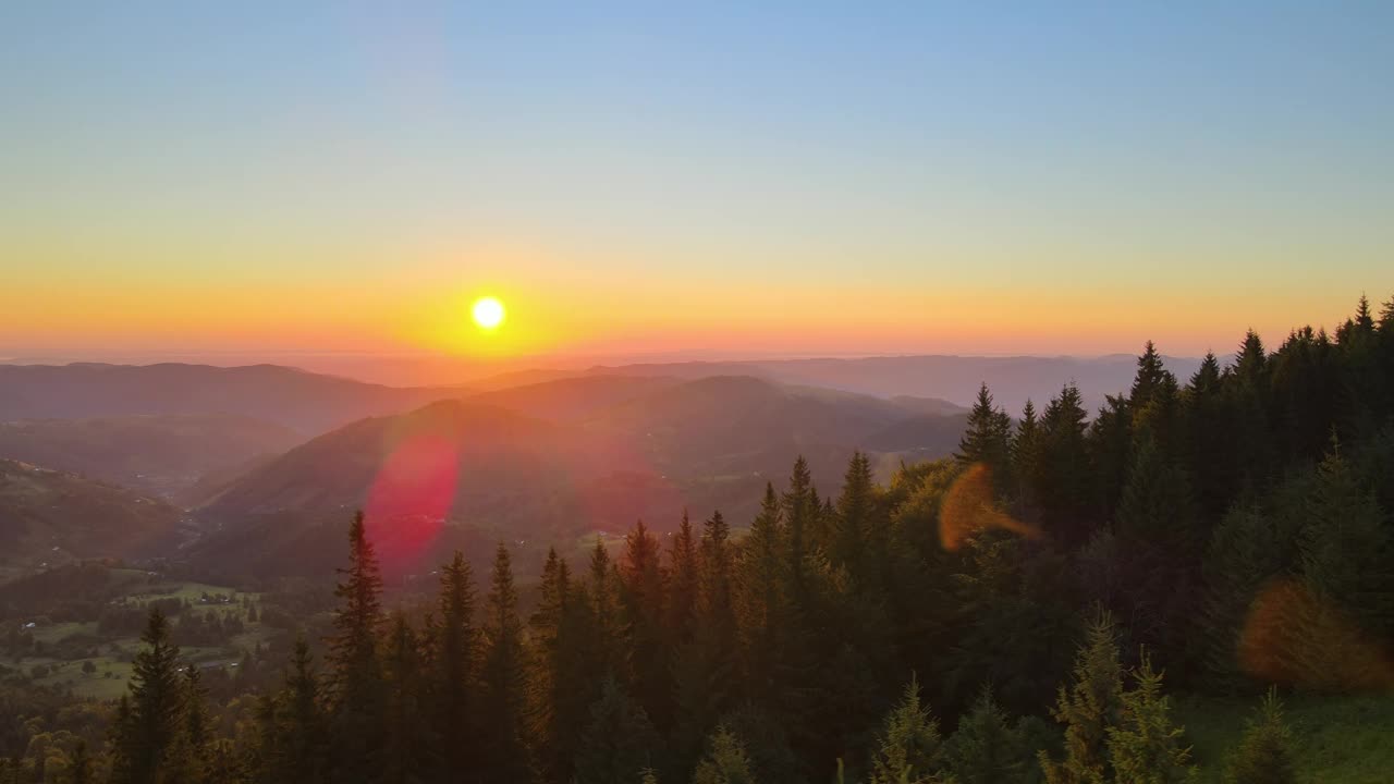 令人惊叹的山地景观。黑暗的云杉树林被黄色的夕阳照亮。在野生国家公园高地上明亮多彩的日落视频素材