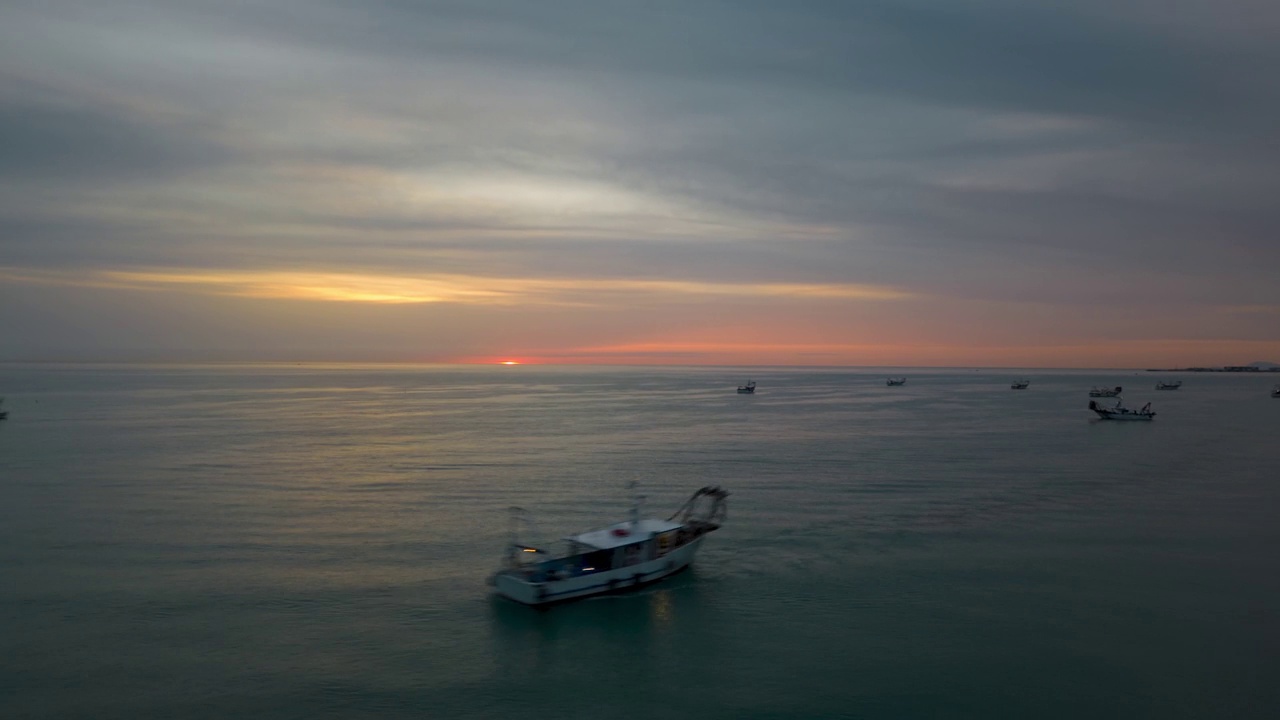 在多云的晚霞下，湛蓝的海面上船只的时间流逝视频素材