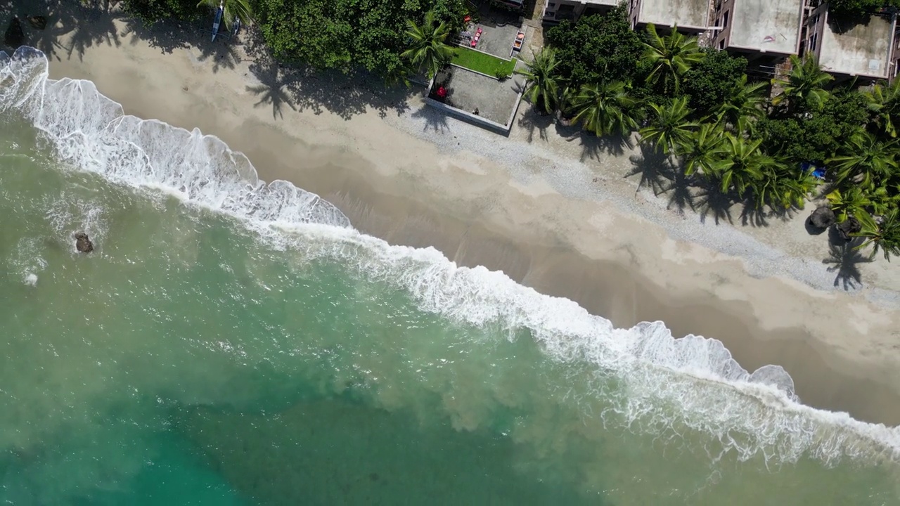 热带地区的海浪和海滩附近的建筑物视频素材