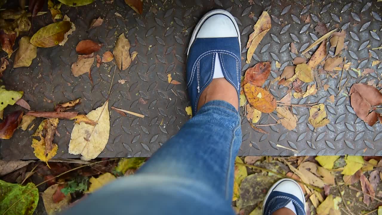 年轻的女旅行者坐在夏日公园里。关注森林公园小路上的运动鞋和牛仔裤。积极活动假期徒步登山徒步方式。年轻旅行者概念视频素材