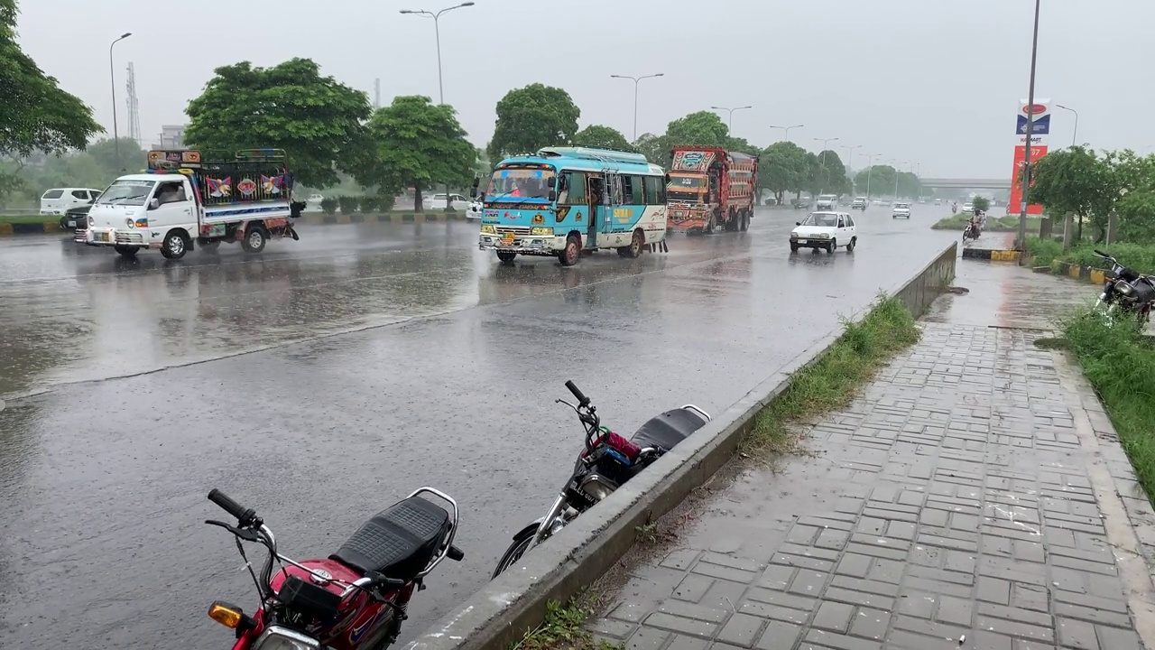 车辆在大雨中行驶，水花飞溅。视频素材