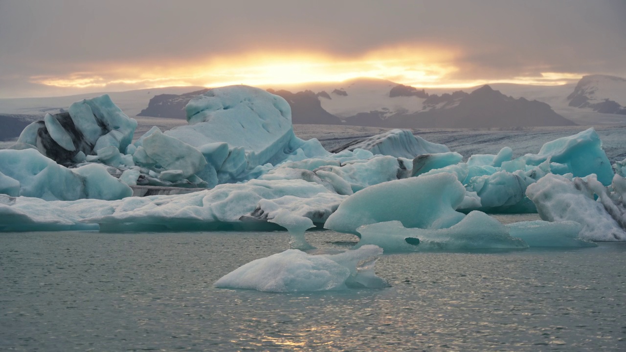 夕阳照耀着冰岛的Jokulsarlon冰川泻湖和蓝色冰山视频素材