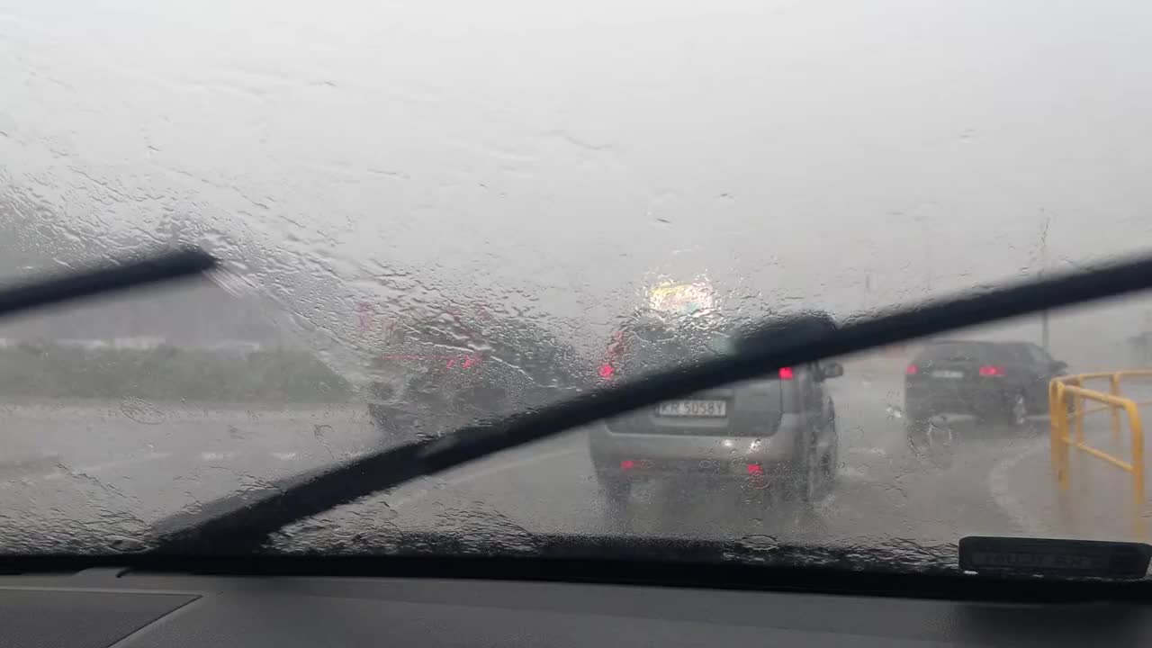 在狂风暴雨的天气里驾车行驶在蜿蜒的道路上。快速工作的雨刷视频下载