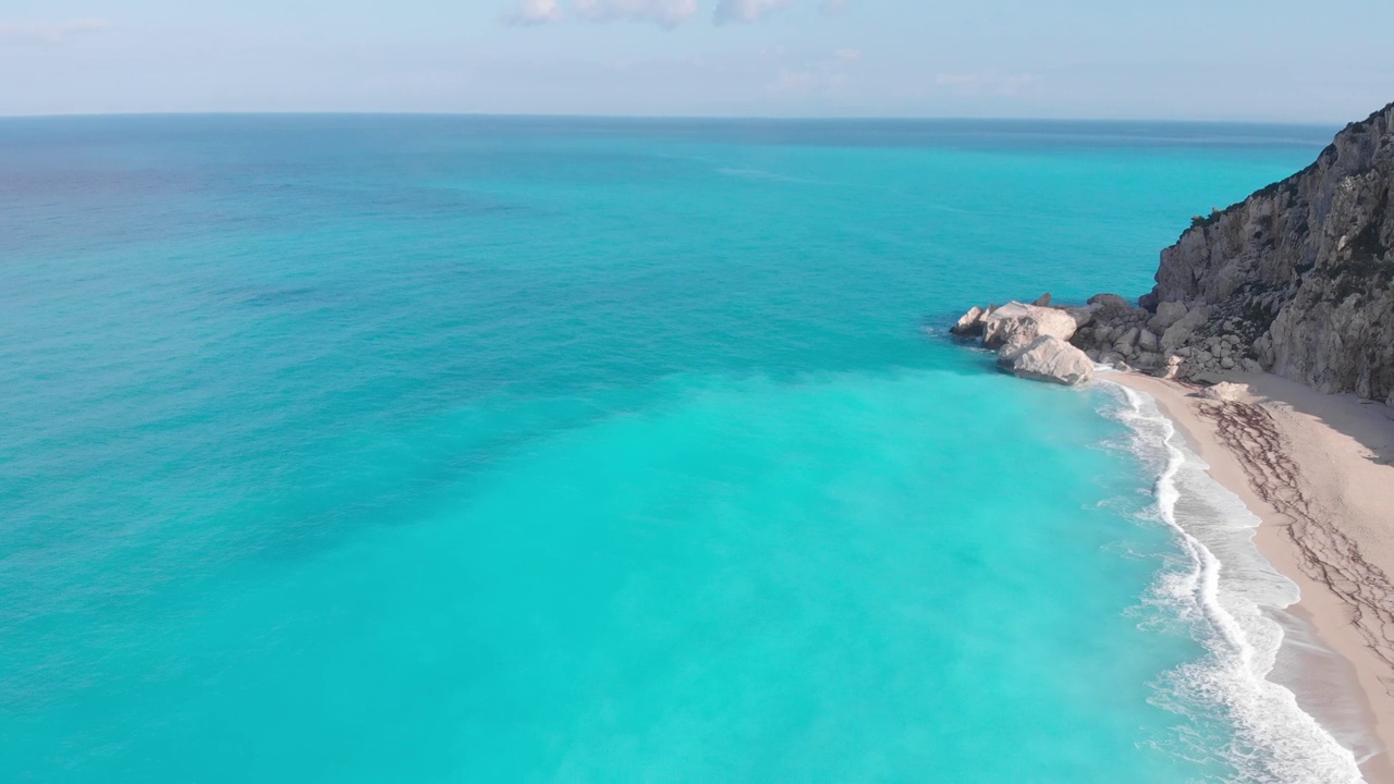 空中美丽的海滩和水湾在希腊壮观的海岸线。碧蓝透明的海水，独特的岩石悬崖，希腊夏季旅游的首选目的地莱夫卡达岛视频下载