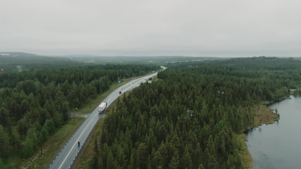 在忧郁的一天，从上面看到不同的车辆行驶在北欧风景的道路上视频素材