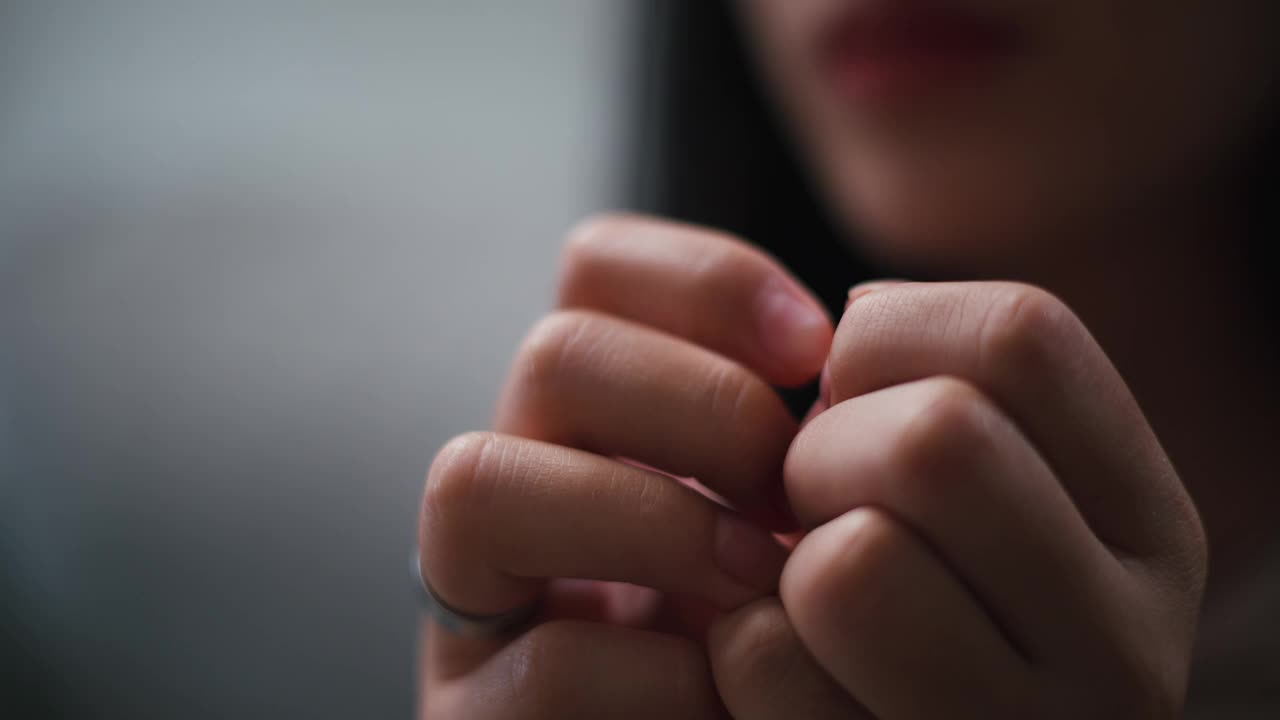 忧郁忧郁的年轻亚洲女子坐在家里的沙发上，看着天花板思考着视频素材