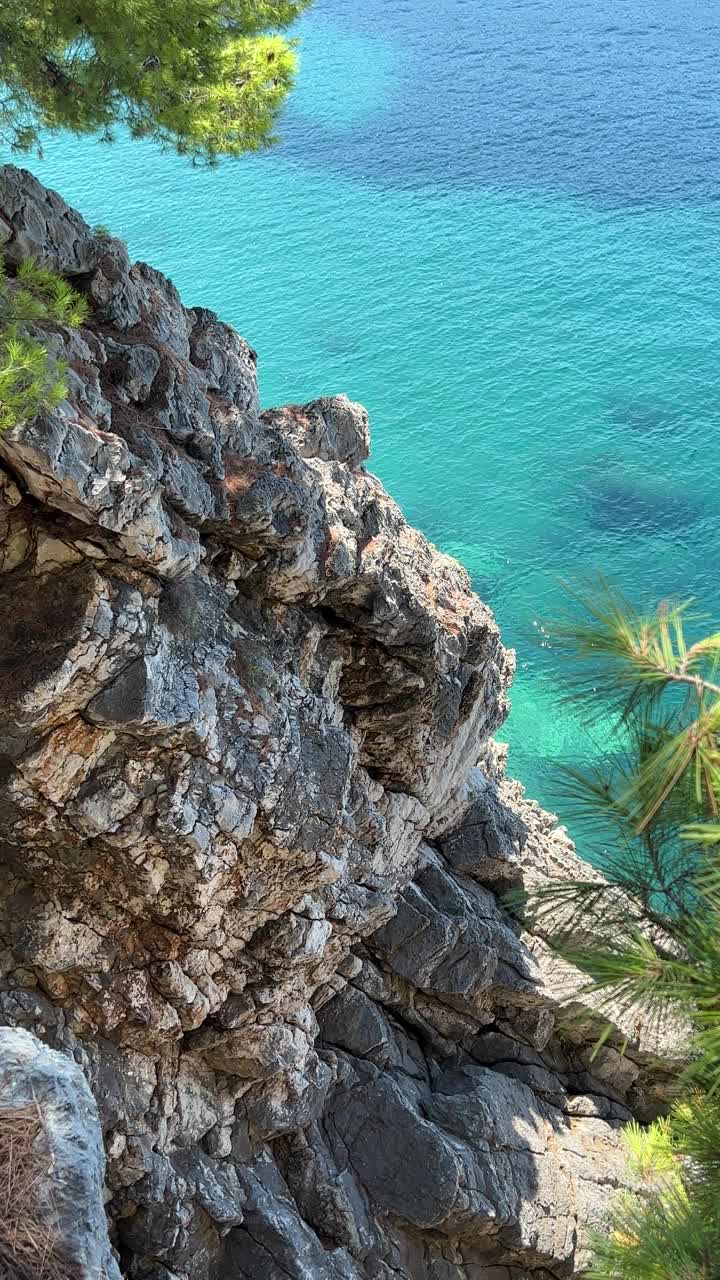 岩石和大海碧蓝碧水生动，垂直视频。视频素材