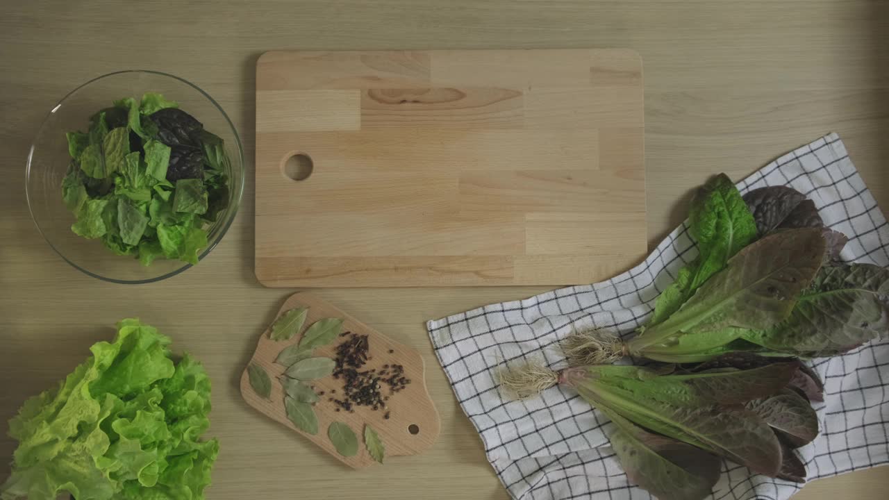 在菜板上切莴苣叶吃。健康食品，蔬菜素食沙拉，生酮旧石器饮食，俯视图视频素材