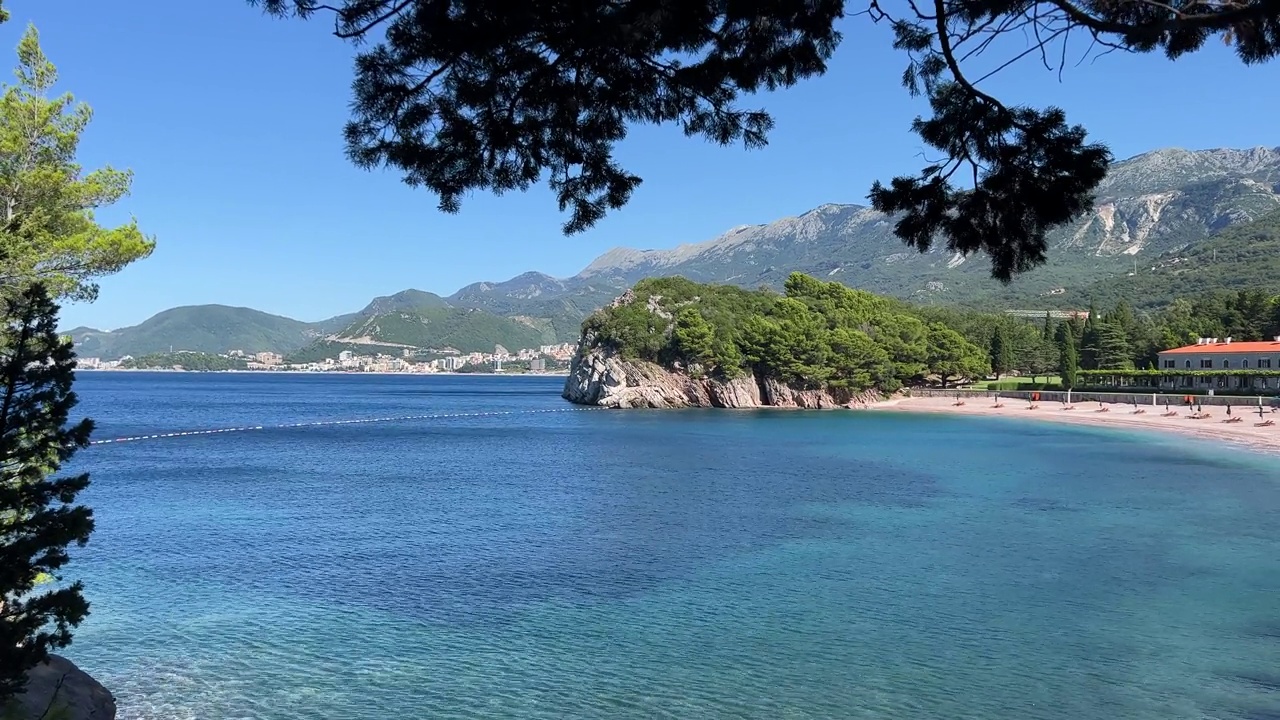 蔚蓝的海水，美丽的海滩和岸边的松树在夏天的晴天。视频素材