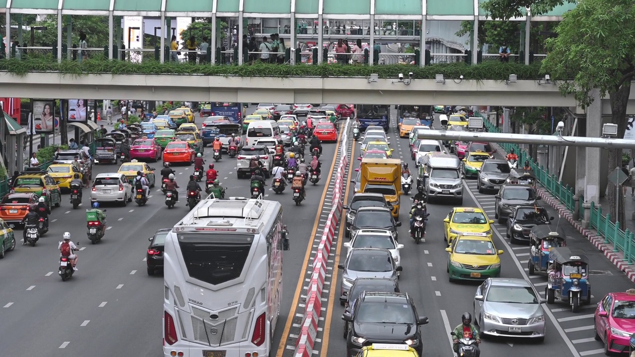 泰国曼谷世界中心附近的道路交通上，拥挤的人群穿过儿童公路车视频素材