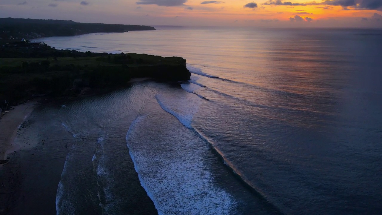 巴厘岛的海岸线有海洋、波浪和美丽的日落或日出。鸟瞰图视频素材