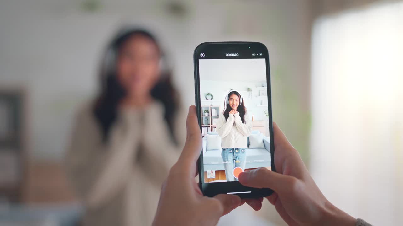 快乐的年轻亚洲视频博主和她的朋友一起用智能手机相机拍摄舞蹈视频，在社交媒体上分享视频视频素材