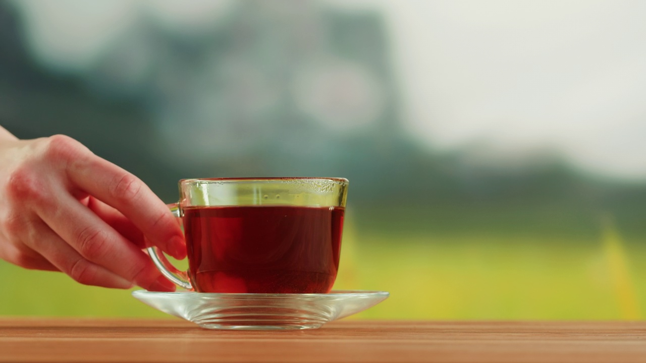 木桌上的红果茶装在玻璃杯里。芙蓉茶道工艺，健康清晨，新鲜冲泡排毒饮品。视频素材