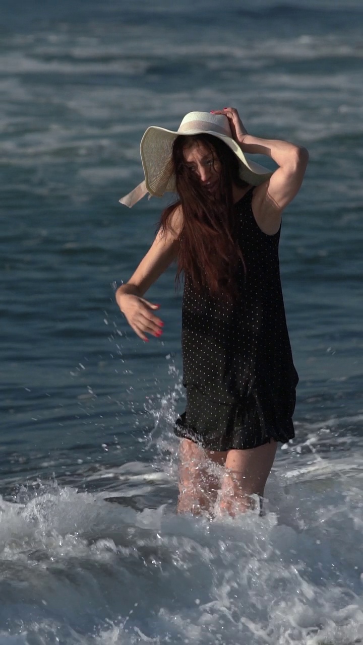 白种人赤脚妇女在打破海浪和溅在沙滩上的夏季海滩假期视频素材