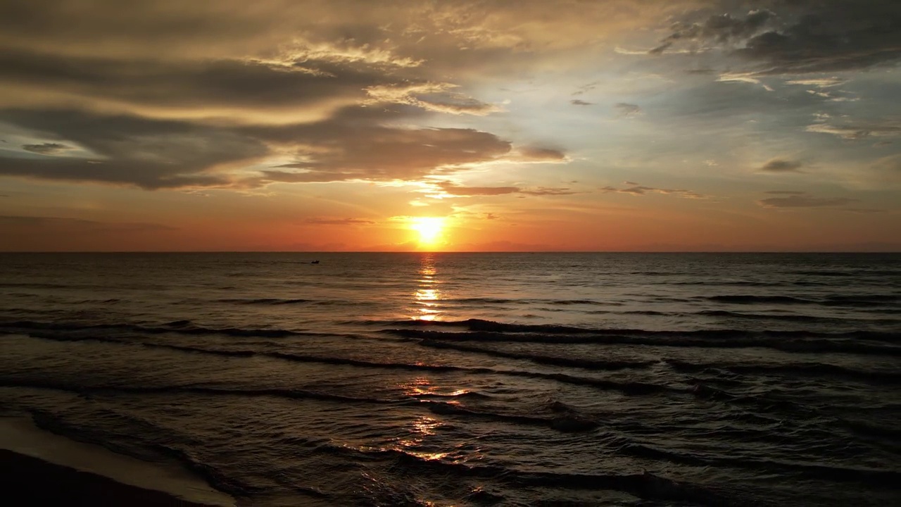 在日落的夜晚鸟瞰美丽的海洋。夏日日落时的海洋俯视图-缩小。无人机拍摄的风景慢动作海浪。海洋上美丽的日落。视频素材