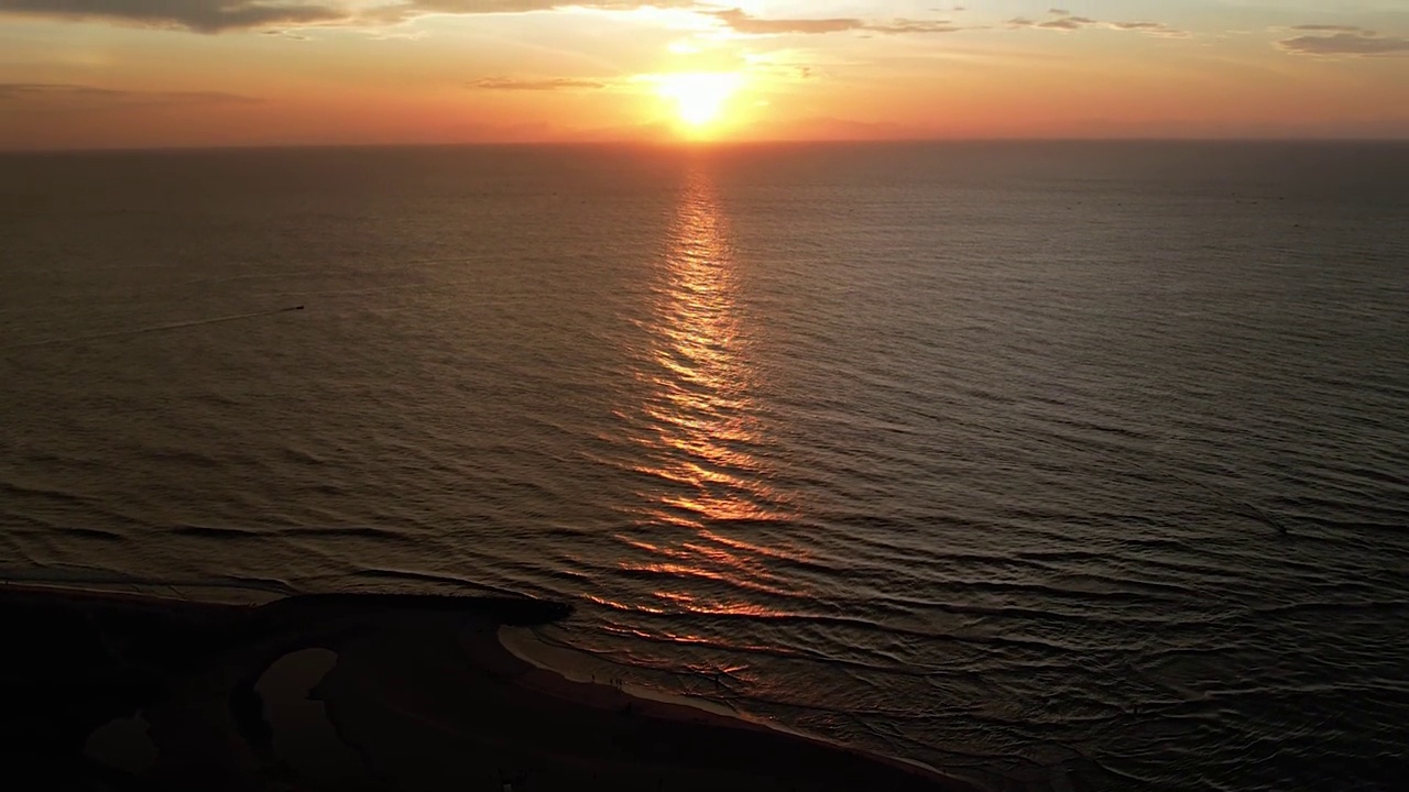 在日落的夜晚鸟瞰美丽的海洋。俯视图到海洋在夏天的一天，而日落-特写。无人机拍摄的风景慢动作海浪。海洋上美丽的日落。视频素材