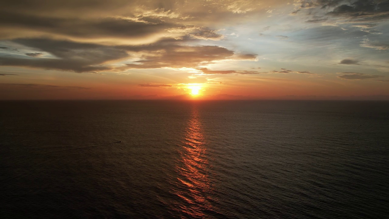 在日落的夜晚鸟瞰美丽的海洋。俯视图到海洋在夏天的一天，而日落-特写。无人机拍摄的风景慢动作海浪。海洋上美丽的日落。视频素材