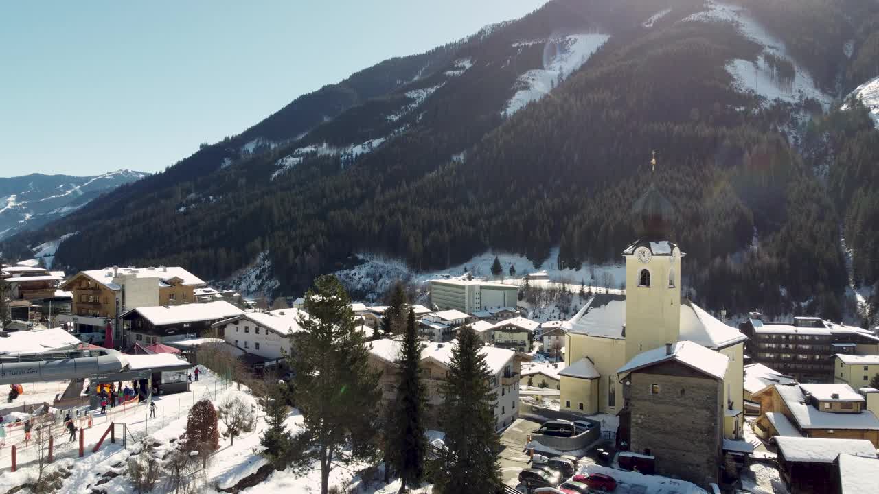 山丘之间积雪覆盖的住宅建筑上的无人机视图视频素材