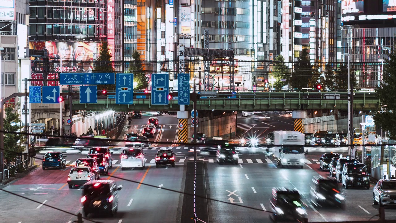 在日本东京新宿，公路上的汽车交通运输，铁路轨道上的地铁列车，日本人走过斑马线的时间流逝。亚洲通勤交通，亚洲城市夜生活视频下载