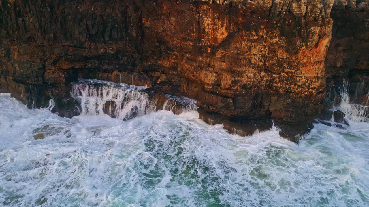 惊涛骇浪飞溅撞击高高的岩石鸟瞰图。危险的海洋泡沫。视频素材