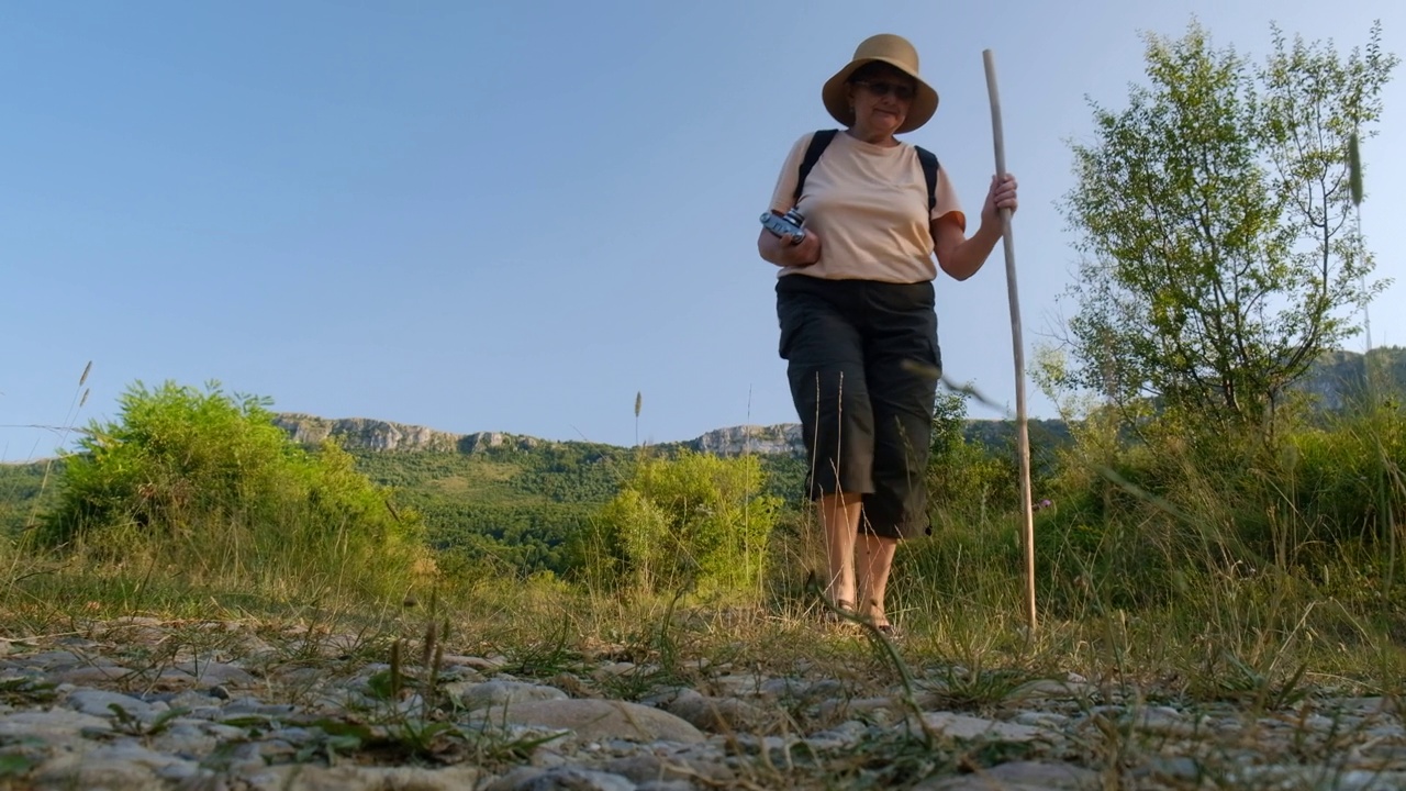 夏天，一个成熟的女人走在山林小径上视频素材