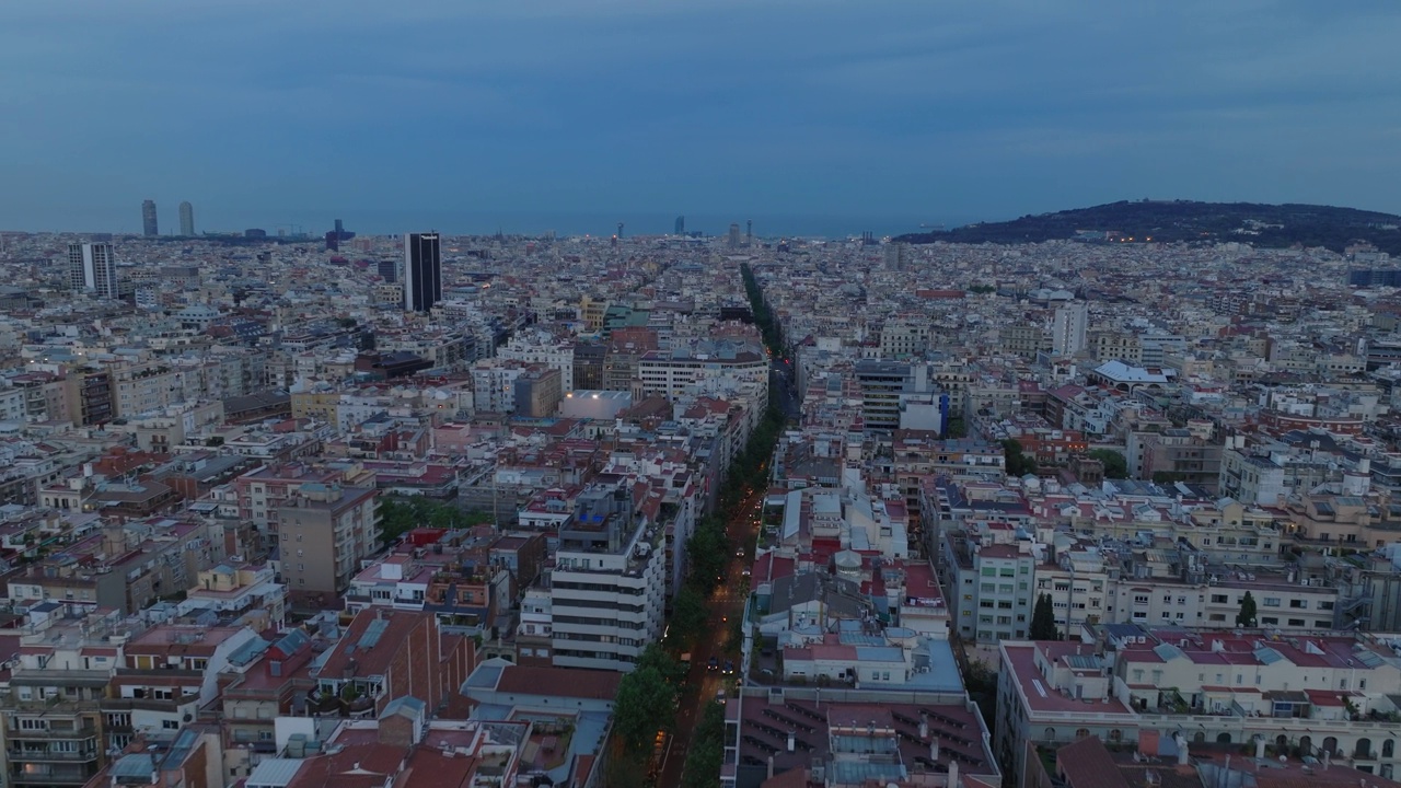 在市区的街道和公寓楼上空飞行。黄昏时的都市风光。西班牙巴塞罗那视频素材